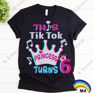 K&ouml;nnte beinhalten: Schwarzes T-Shirt mit einem pinkfarbenen und blauen Design, auf dem "This Tik Tok Princess Turns 6" mit einer silbernen Glitzerkrone und Noten steht.