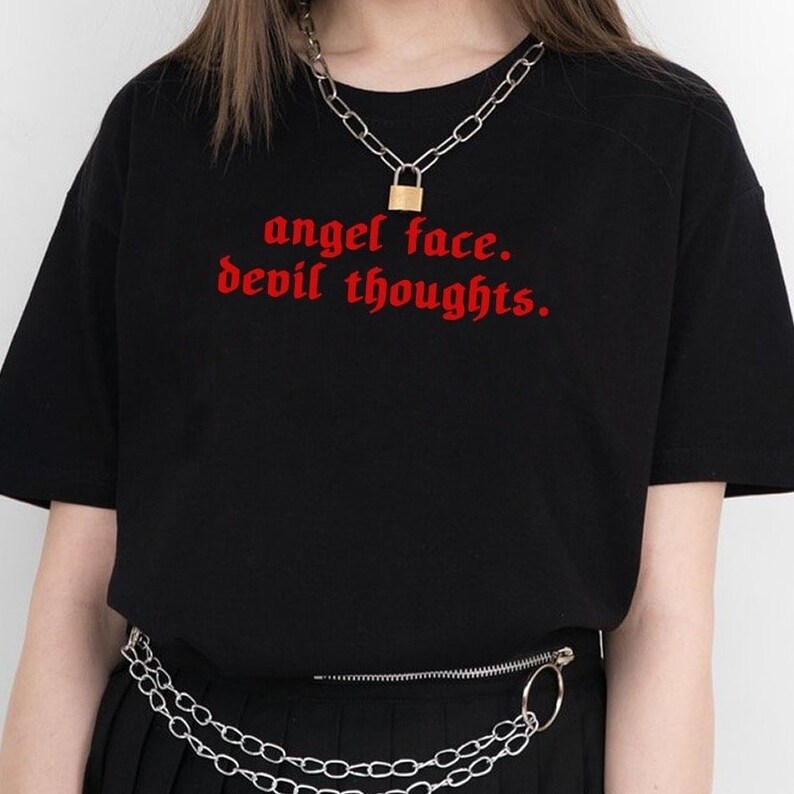May include: Black t-shirt with red text that reads "angel face. devil thoughts."