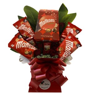 Puede incluir: Una cesta de regalo roja y blanca llena de chocolate Maltesers. La cesta está decorada con una cinta roja y hojas verdes. El texto en la caja dice "Maltesers Creamy Crunchy Treats".