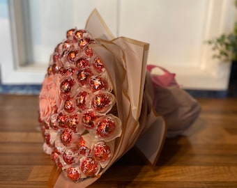Gran ramo de regalo atado a mano de chocolate Lindt Lindor y flores.