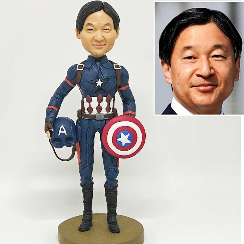 May include: A custom-made figurine of a person dressed as Captain America. The figurine is holding a shield and a helmet. The person's face is a realistic portrait.