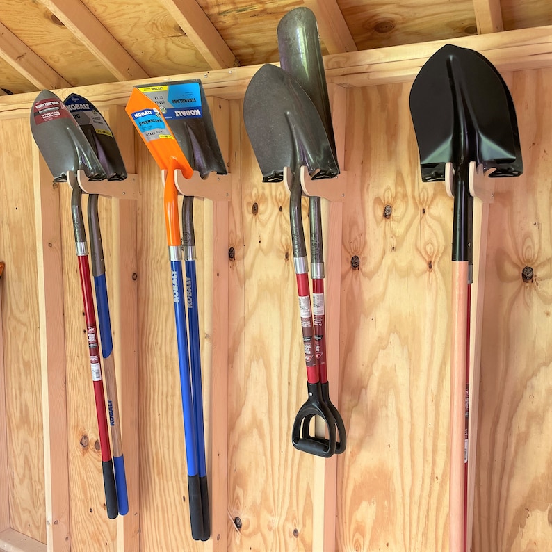 K&ouml;nnte beinhalten: F&uuml;nf verschiedene Schaufeln h&auml;ngen an einer Holzwand. Die Schaufeln sind alle in verschiedenen Farben und Gr&ouml;&szlig;en. Die Schaufeln sind mit der Marke "KOBALT" gekennzeichnet.