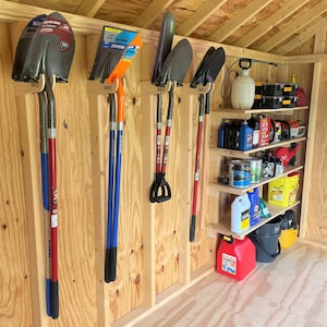 May include: A wooden shed with a variety of gardening tools hanging on the wall. The tools include shovels, rakes, and a broom. There are also shelves with various items, including paint cans, cleaning supplies, and other gardening tools.