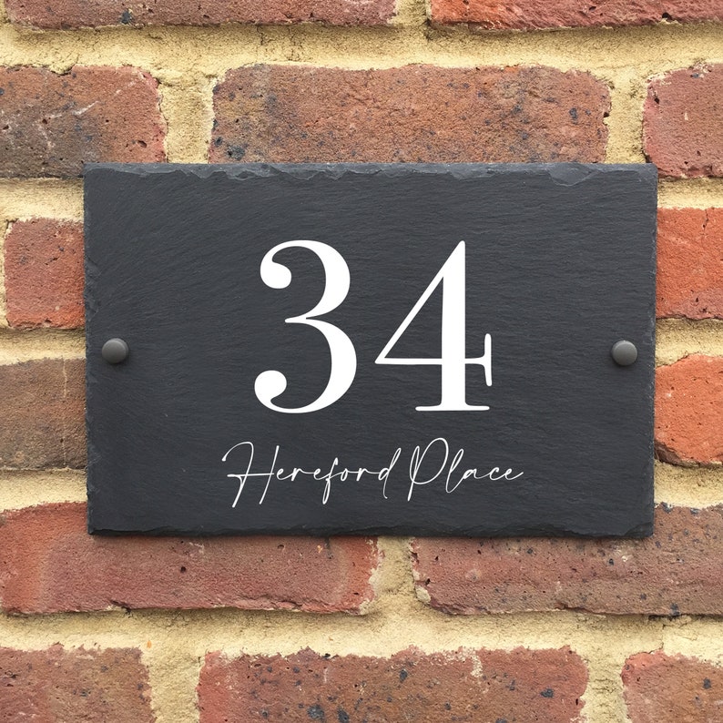 May include: Black slate house number sign with white lettering. The number 34 is displayed with the text "Hereford Place" underneath.