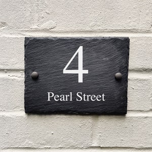 May include: Black slate house number sign with white text. The number 4 and the words "Pearl Street" are on the sign.
