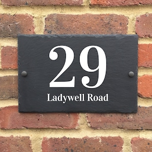 May include: Black slate house number sign with white lettering. The number 29 is displayed with the street name "Ladywell Road" underneath.