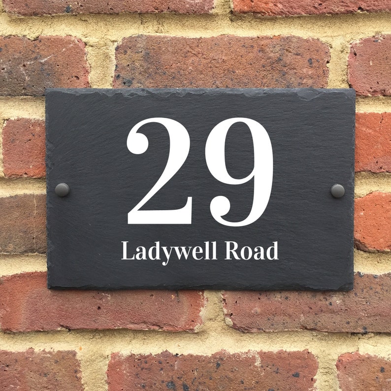 May include: Black slate house number sign with white lettering. The number 29 is displayed with the street name "Ladywell Road" underneath.