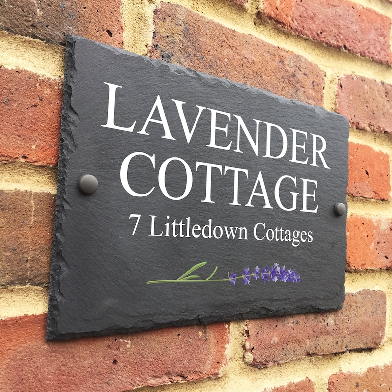 May include: Black slate house number sign with white text that reads "Lavender Cottage" and "7 Littledown Cottages". A small lavender sprig is depicted in the bottom right corner.