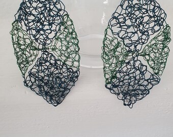 May include: A pair of dangle earrings made of wire, with a blue and green colour scheme. The earrings are shaped like a leaf and have a delicate, intricate design.
