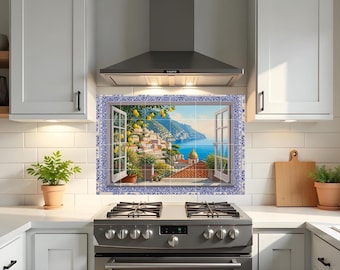 May include: A kitchen backsplash featuring a scenic view of a coastal Italian town. The artwork depicts an open window overlooking the sea, with lemon trees, buildings, and a blue and white tile border. The scene is set above a stainless steel gas range.