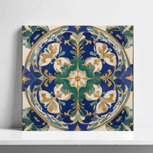 May include: Square decorative tile with a detailed floral design. The tile features a central circular pattern with blue, green, gold, and white colors. The design includes stylized leaves and floral elements, creating a symmetrical and ornate appearance.