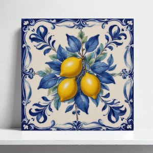 Puede incluir: Azulejo cerámico cuadrado con diseño de rama de limón. Presenta tres limones amarillos, hojas azules y un fondo crema, enmarcado por un borde floral azul. Una pieza decorativa para la cocina o el comedor, de aproximadamente 20 cm x 20 cm.