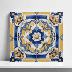 May include: Square ceramic tile with a floral design in shades of blue, yellow, and white. The central flower is surrounded by stylized leaves and a border of yellow and blue. The tile is likely for decorative use.