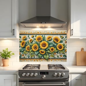 Könnte beinhalten: Eine dekorative Küchenrückwand mit einem Sonnenblumen-Design. Das Kunstwerk zeigt große gelbe Sonnenblumen mit grünen Blättern auf cremefarbenem Hintergrund, umrahmt von einem dekorativen Rand. Die Rückwand ist über einem Gasherd installiert.
