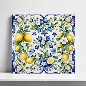 Può includere: Arte su tela quadrata con un design ad acquerello di limoni, fiori bianchi e accenti floreali blu. L'opera d'arte ha uno sfondo bianco e un bordo blu decorativo. I limoni sono gialli e le foglie sono verdi.