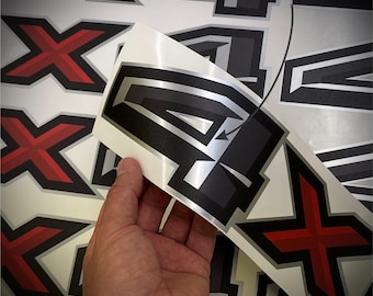 May include: A sheet of adhesive decals featuring the number 4 in a metallic silver and black design, alongside red and black X-shaped symbols. The text "METALLIC SILVER" is printed at the top, and a "MADE IN THE USA" flag icon is in the corner.