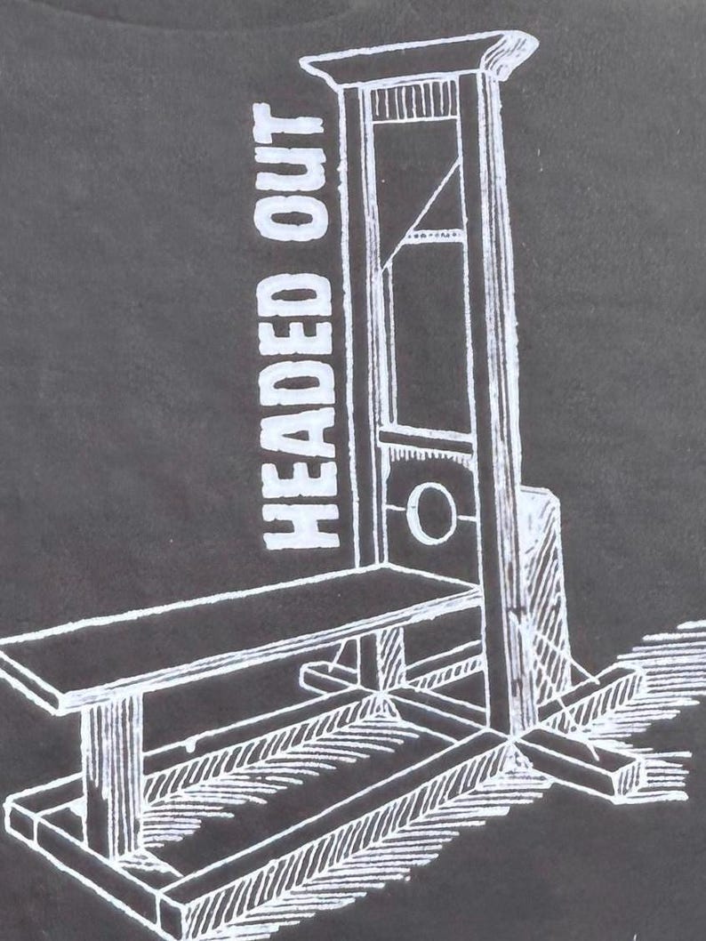 以下が含まれることがあります： 暗い灰色の背景に、ギロチンの白い線画。 「HEADED OUT」というテキストが画像の左側に縦に印刷されています。 ギロチンは、ベンチ、刃、直立フレームで描かれています。