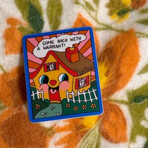 May include: A colorful sticker with a cartoon house design. The house has a smiling face, a red roof, and a white picket fence. Text on the sticker reads, "COME BACK WITH A WARRANT!" The sticker has a blue border and is set against a floral background.
