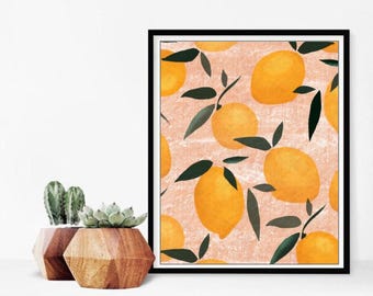 Könnte beinhalten: Ein gerahmter Kunstdruck mit einem sich wiederholenden Muster aus gelben Zitronen und grünen Blättern auf einem strukturierten pfirsichfarbenen Hintergrund. Das Kunstwerk befindet sich in einem schwarzen Rahmen. Zwei dekorative Holzpflanzgefäße mit Sukkulenten befinden sich im Vordergrund.