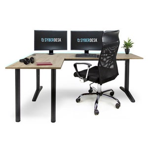 Könnte beinhalten: Ein schwarzer L-förmiger Schreibtisch mit Holzmaserung. Zwei Computermonitore stehen auf dem Schreibtisch, einer mit dem Text "SYBERDESK" auf dem Bildschirm. Ein schwarzer Netz-Bürostuhl mit verstellbaren Armlehnen steht vor dem Schreibtisch.