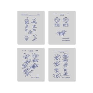 Op de afbeelding: Een set van vier vintage blauwdruk-stijl prints van de LEGO-patenttekeningen. De prints zijn in tinten blauw en grijs en tonen verschillende LEGO-steenontwerpen en een LEGO-minifiguur.