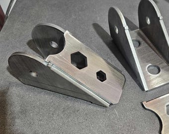 May include: Three metal brackets with multiple holes and rounded edges. The brackets are made of a silver-colored metal and have a rough, unfinished texture.
