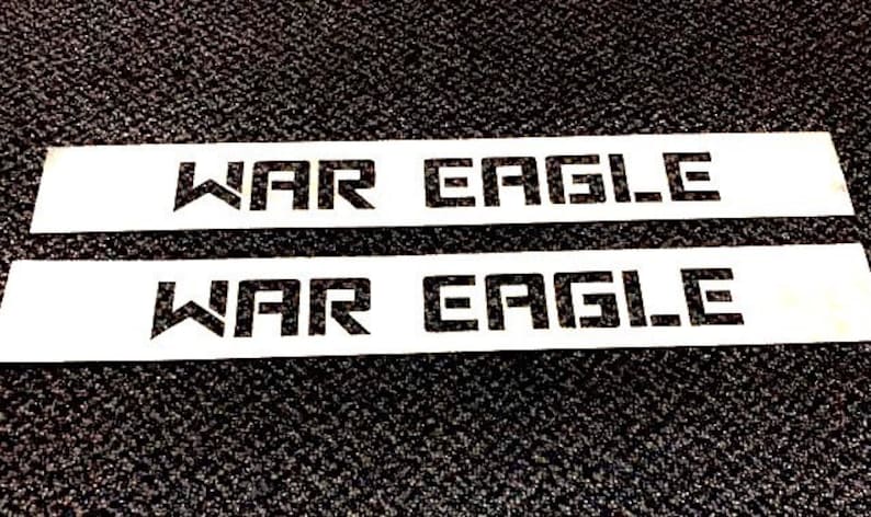 May include: Two white rectangular signs with the text "WAR EAGLE" printed in black.