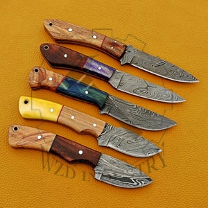 May include: Five different handmade knives with Damascus steel blades and wooden handles. Each handle has a unique combination of colors and patterns.