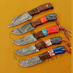 May include: Set of five Damascus steel knives with wooden handles and colorful inlays. Each knife has a different colored inlay, including red, blue, and black. The knives are arranged in a row on a yellow surface.