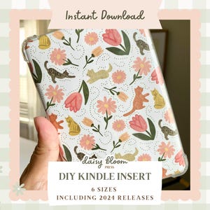 May include: A clear phone case with a white background and a floral pattern featuring pink flowers, green leaves, and brown cats. The text "Daisy Bloom Press" and "DIY Kindle Insert" is printed on the case. The text "6 Sizes" and "Including 2024 Releases" is printed below the main text.
