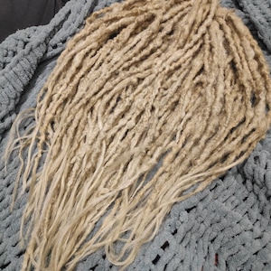 May include: A set of long, blonde synthetic dreadlocks. The dreadlocks are made of a soft, lightweight material and are perfect for adding length and volume to your hair.
