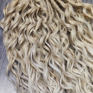 May include: A bundle of blonde and light blonde curly synthetic dreadlocks. The dreadlocks are about 20 inches long and have a wavy texture.