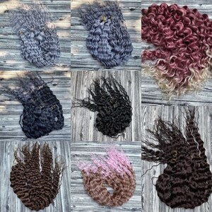 May include: Nine bundles of curly hair extensions in various colors, including black, brown, gray, pink, and red. The hair extensions are arranged in a grid pattern on a wooden surface.