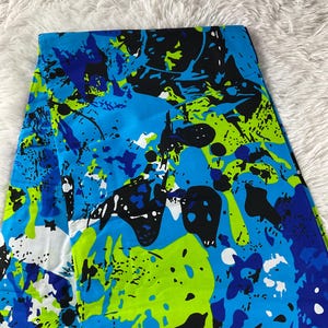 May include: Abstract print fabric in shades of blue, green, black and white. The fabric has a modern, abstract design with large, bold shapes.
