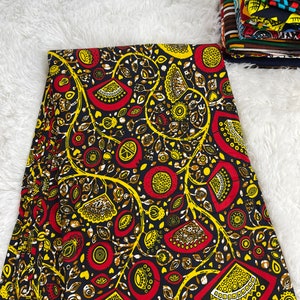 Könnte beinhalten: Ein schwarzer Stoff mit einem sich wiederholenden Muster aus gelben, roten und braunen stilisierten Blumen und Blättern.