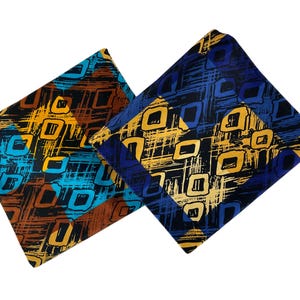 May include: Two folded pieces of fabric featuring a geometric pattern of black, yellow, and blue squares overlaid on a textured, cross-hatched background. One piece incorporates brown tones, while the other displays deep blue and black color accents.