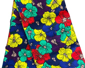 May include: A vibrant fabric featuring a repeating floral pattern. The design showcases large flowers in shades of red, yellow, green, blue, and purple against a dark blue background. The fabric is likely used for clothing or home decor.