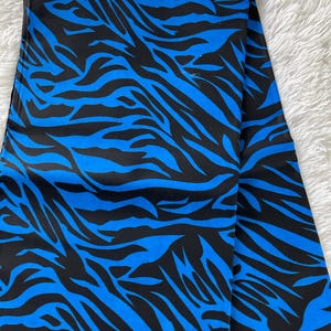 May include: Blue and black fabric with a zebra print pattern.