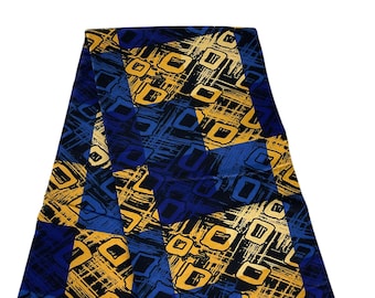May include: A folded piece of fabric featuring a geometric pattern of blue and yellow squares and rectangles. The design includes dark blue, light blue, and golden yellow hues with a textured, brushstroke-like background. The text FIRST CHOICE is visible.