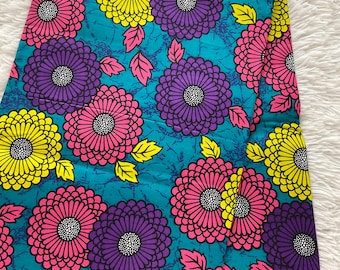 May include: Bright fabric with a repeating floral design. Large flowers in pink, yellow, and purple are set against a teal background with a subtle textured pattern. The fabric is decorated with pink and yellow leaves.