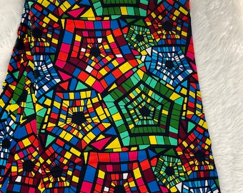 Könnte beinhalten: Bunter Stoff mit einem geometrischen Muster aus Quadraten und Kreisen in Rot-, Gelb-, Blau-, Grün- und Schwarztönen.