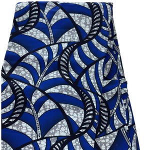 May include: Blue and white fabric with a geometric pattern of curved lines and shapes. The fabric has a textured surface.