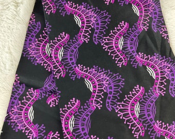 May include: Purple and pink floral pattern on a black fabric background. The pattern features a repeating design of stylized flowers with white accents.