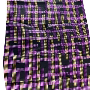 May include: A fabric with a geometric pattern. The design features a grid of intersecting lines in purple, yellow, and pink dots against a black background. The fabric has a shiny appearance and a repeating pattern.