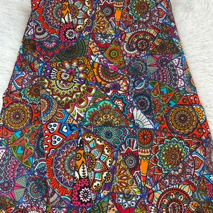 May include: A colorful fabric with a repeating pattern of intricate mandalas in shades of red, orange, yellow, green, blue, and purple.