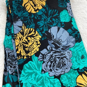 May include: Black fabric with a large-scale floral print in shades of teal, yellow, and gray.