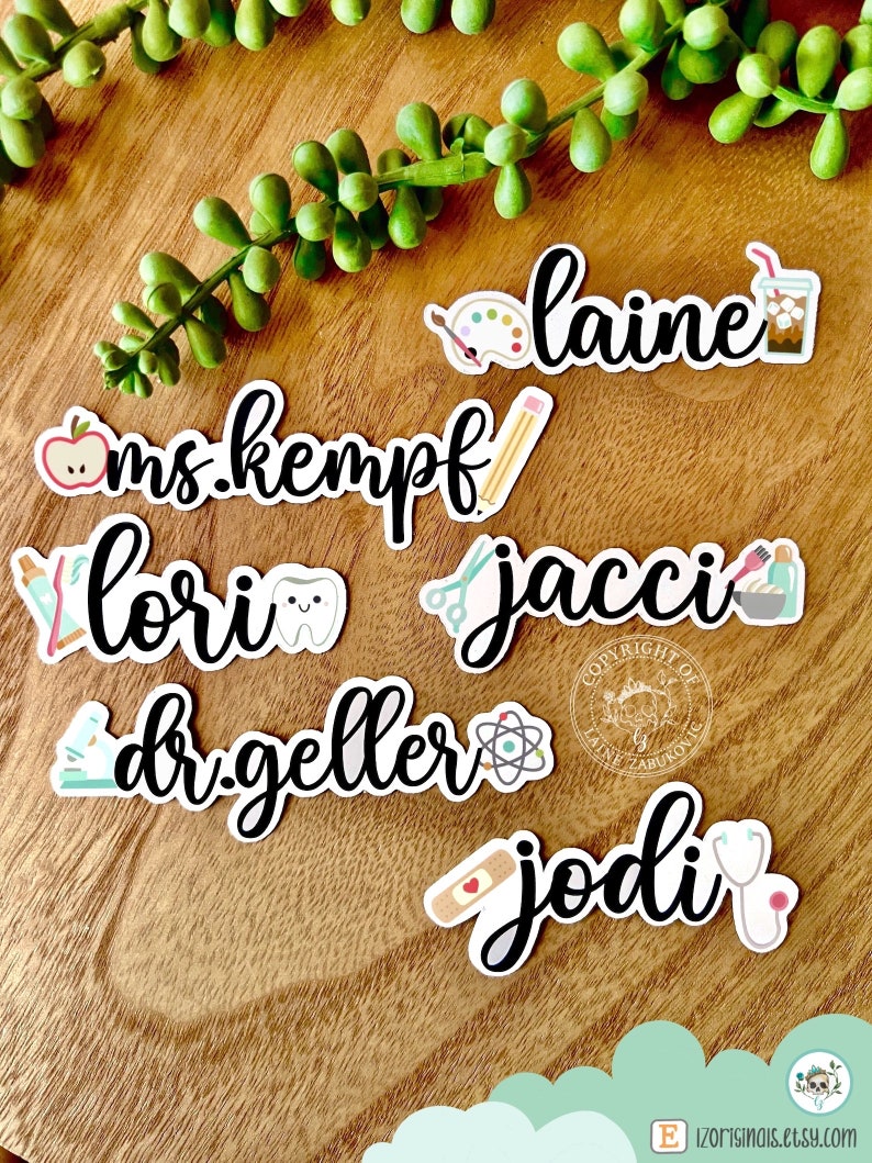 K&ouml;nnte beinhalten: Ein Set mit 6 personalisierten Namenaufklebern mit verschiedenen Symbolen, die verschiedene Berufe repr&auml;sentieren. Die Namen sind "ms. kempf", "lori", "jacci", "dr. geller", "jodi" und "laine".