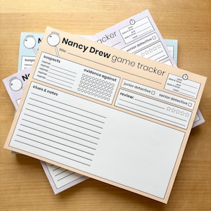May include: A stack of Nancy Drew game tracker sheets in pastel colors. Each sheet has spaces for suspects, clues, notes, and evidence. The title "Nancy Drew game tracker" is printed on the sheets.