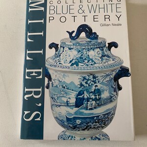 May include: A book titled "Miller's Collecting Blue & White Pottery" by Gillian Neale. The cover features a blue and white porcelain vase with a dolphin finial.