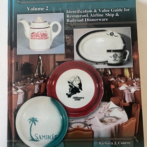 May include: A book titled "RESTAURANT CHINA Volume 2" with images of vintage restaurant china. The cover features a white teapot with red accents, a white oval platter and mug with black trim, and plates with various designs, including "SAMBO'S" and "FISHERMAN'S WHARF".